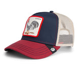 A trucker-style baseball cap with a navy blue front panel, a red brim, and beige mesh back panels. It features a square embroidered patch on the front with a rooster illustration and the word 'COCK'.
