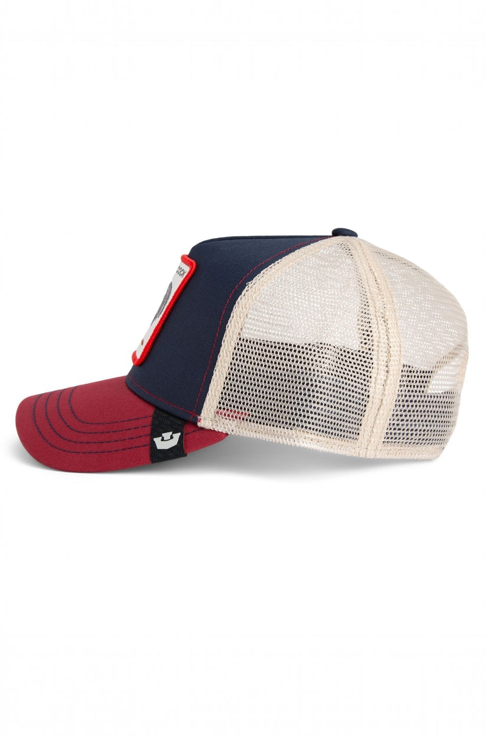 A classic trucker hat featuring a navy blue front panel, a cream mesh back, and a dark red curved brim. A small white embroidered logo is visible on the side of the brim.