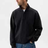 Man wearing a black jacket and blue jeans on a white background