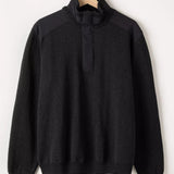 Black sweater on a hanger against a white background