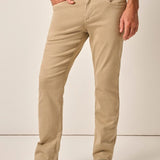Person wearing beige pants and a plaid shirt on a plain background