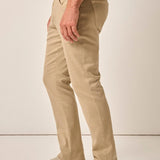 Person wearing beige pants and white sneakers on a plain background
