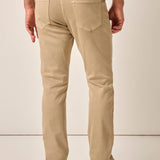 Person wearing beige pants and a plaid shirt on a plain background