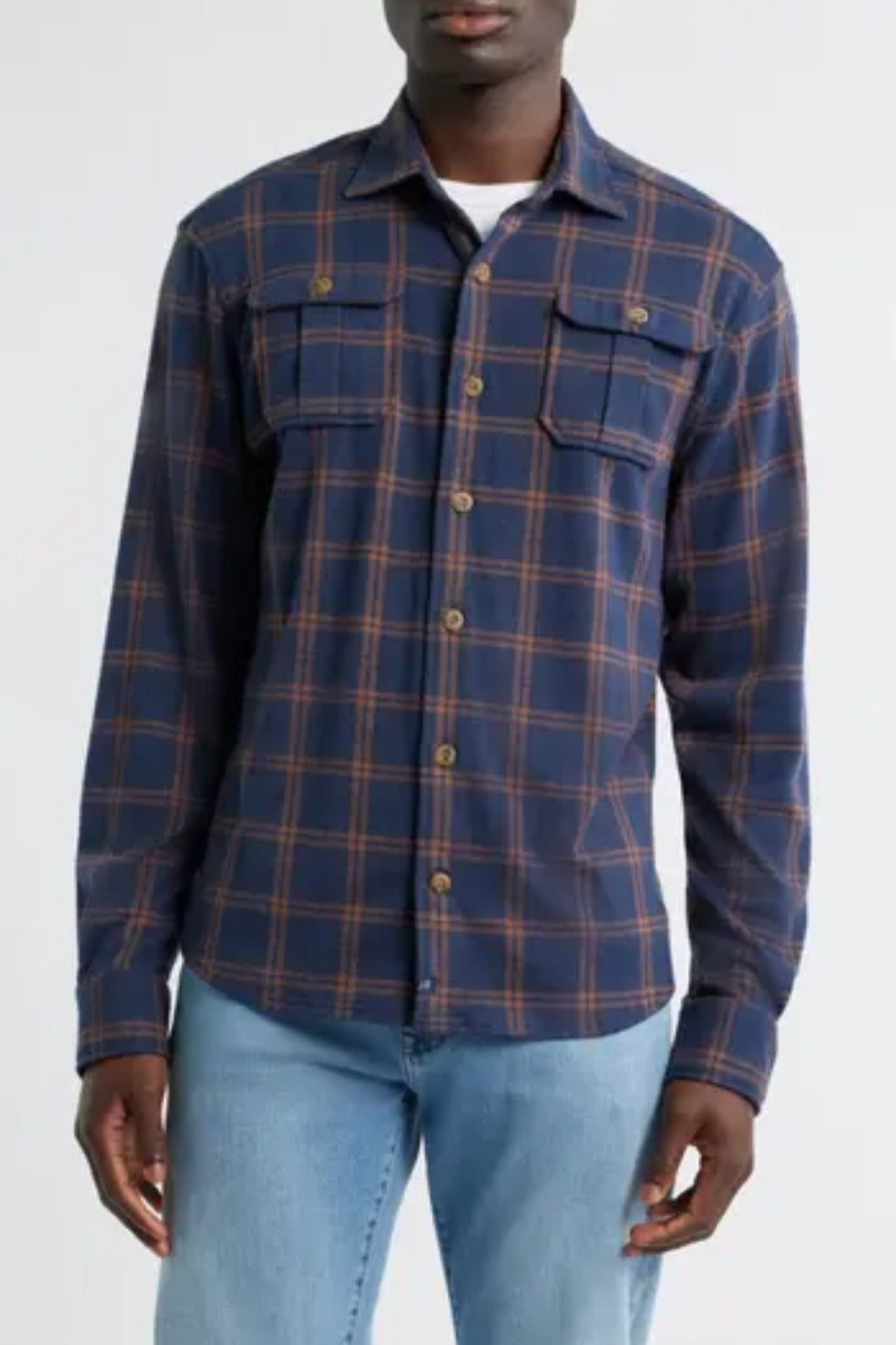 Person wearing a blue plaid shirt with a white background