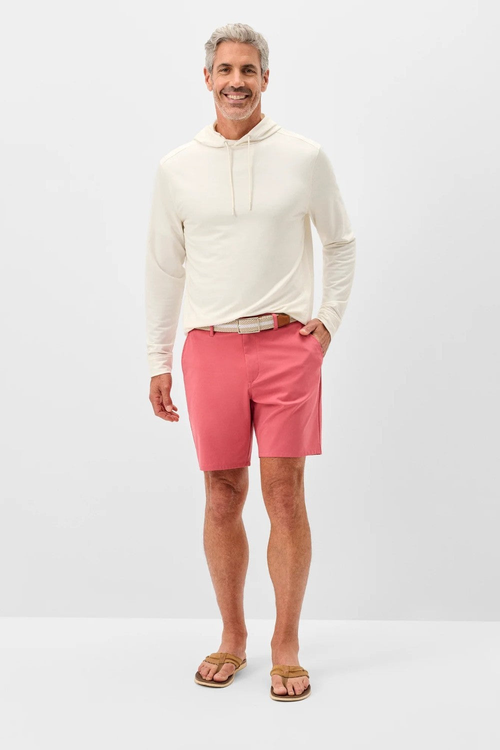 Man wearing a white hoodie and pink shorts on a white background