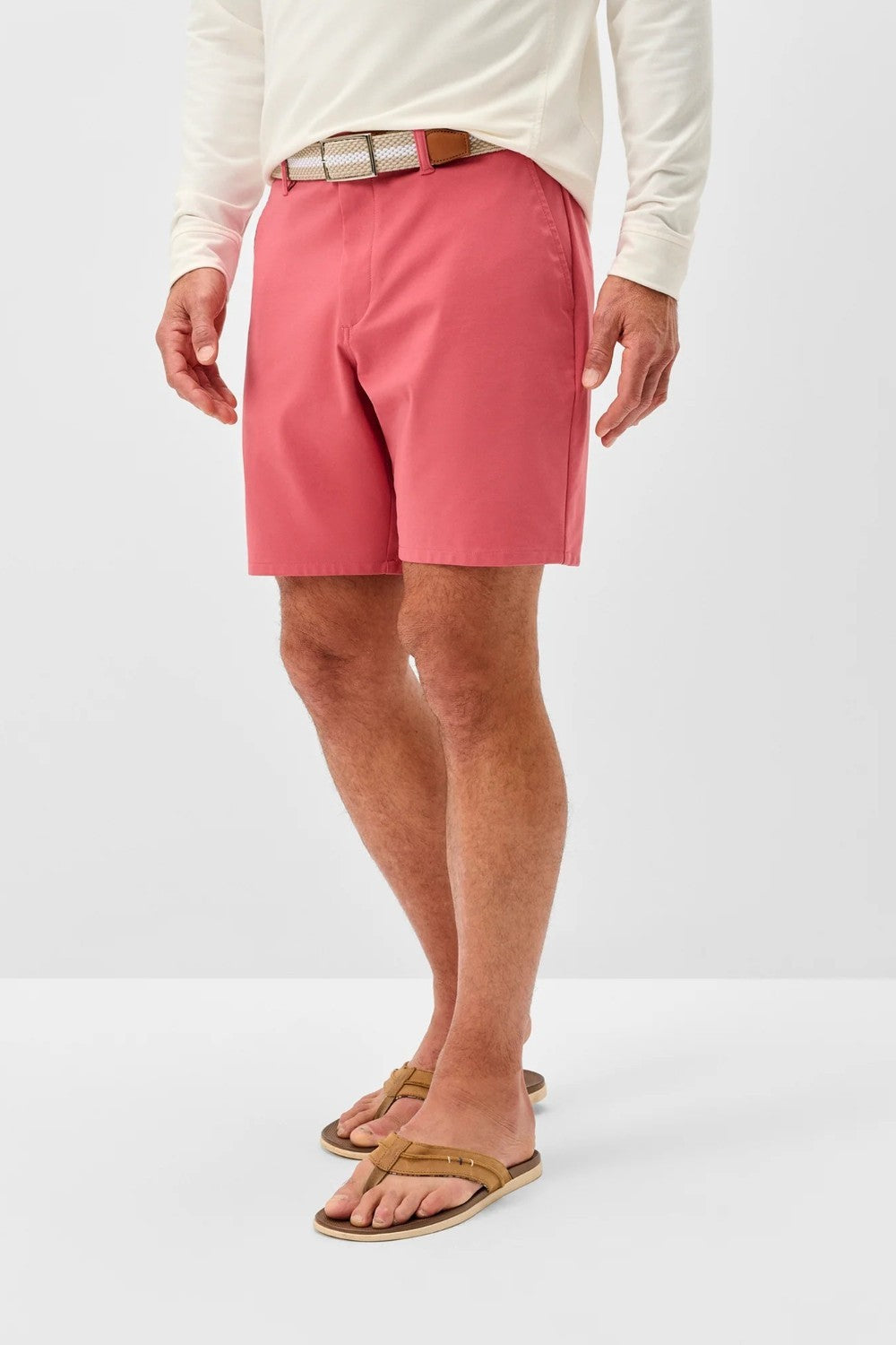 Person wearing pink shorts and a white long-sleeve shirt on a white background