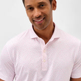 Man wearing a white polo shirt with a subtle pattern against a light gray background