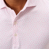 Close-up of a man wearing a pink patterned shirt with a blurred background