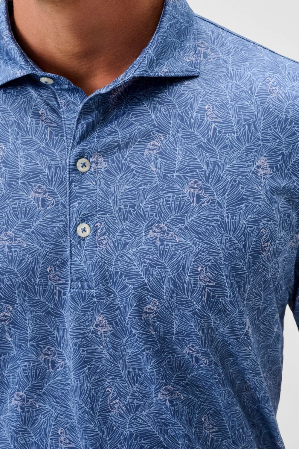 Close-up of a blue patterned shirt with buttons on a plain background