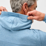 Person wearing a blue hoodie with a plain background