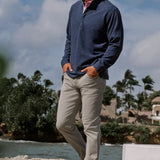 Man standing outdoors with a scenic background of trees and water.