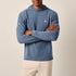 Man wearing a blue hoodie with a logo on a beige background