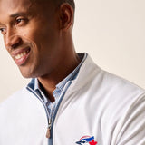 Man wearing a white jacket with a logo on a plain background