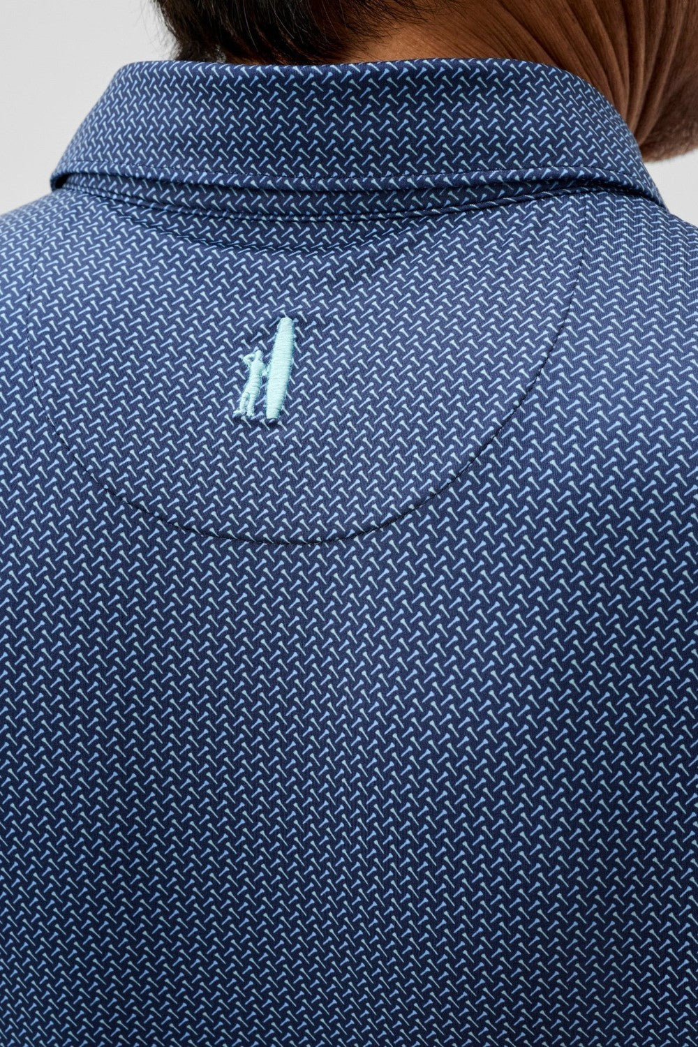 Close-up of a blue textured shirt with a small logo on the chest.