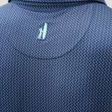 Close-up of a blue textured shirt with a small logo on the chest.