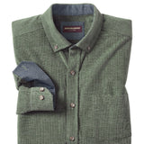 Folded green cardigan with a blue shirt inside on a white background