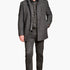 Man wearing a gray coat over a plaid shirt with gray pants on a white background
