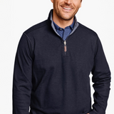 Man wearing a navy blue quarter-zip sweatshirt over a checkered shirt on a white background