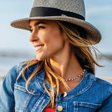The Josie hat redefines the classic fedora with a moldable wire-edged brim and a sleek wide black ribbon band for effortless elegance. Perfectly packable and versatile, it’s your go-to accessory for daytime outings, tropical escapes, or any stylish adventure. Combine style, practicality, and flair with this must-have hat that’s made to turn heads.