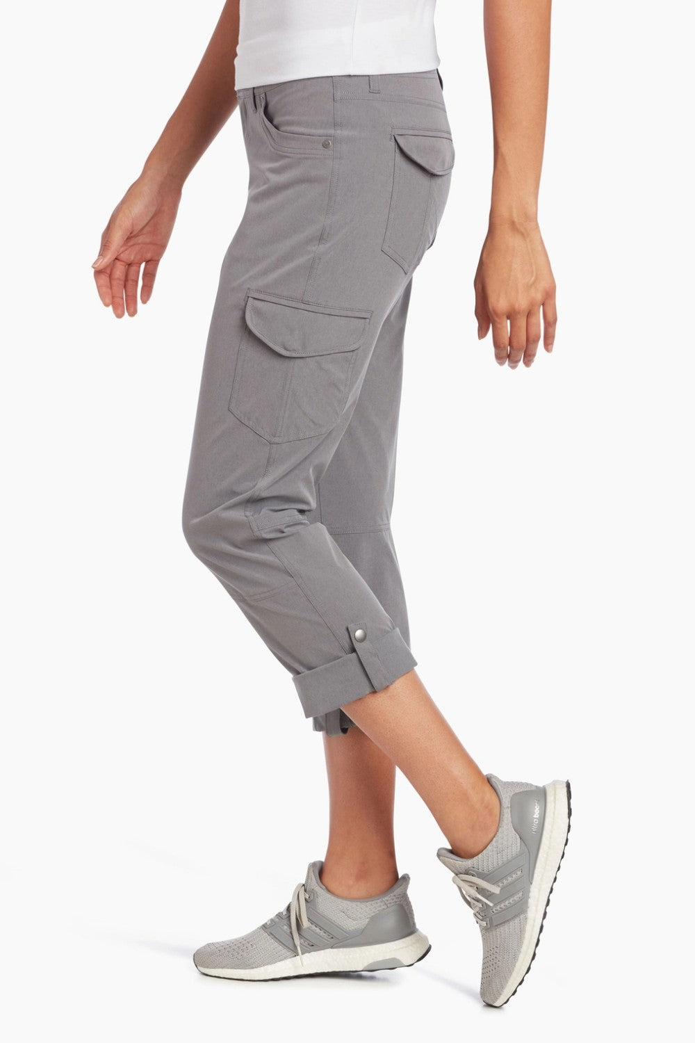 Person wearing gray cargo pants and matching sneakers on a white background