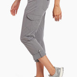 Person wearing gray cargo pants and matching sneakers on a white background