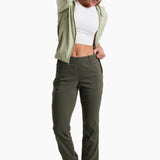Woman wearing a green jacket, white top, and green pants on a white background