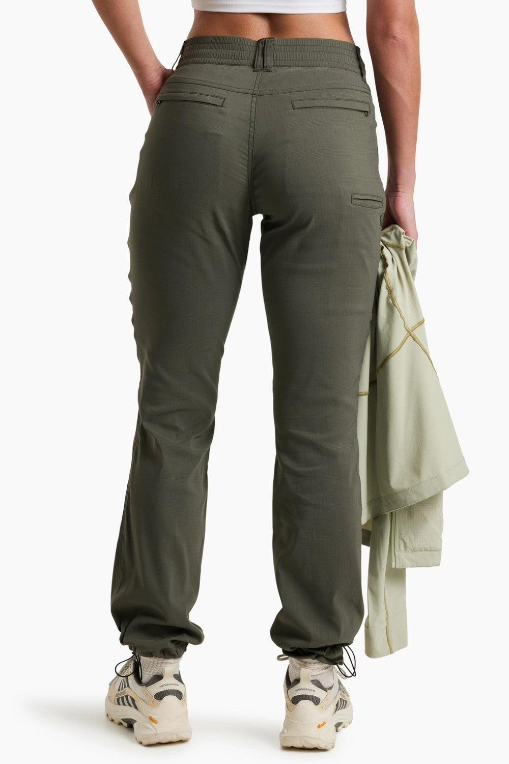 Person wearing green cargo pants with a white background