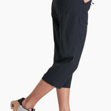 Person wearing black capri pants with a white background