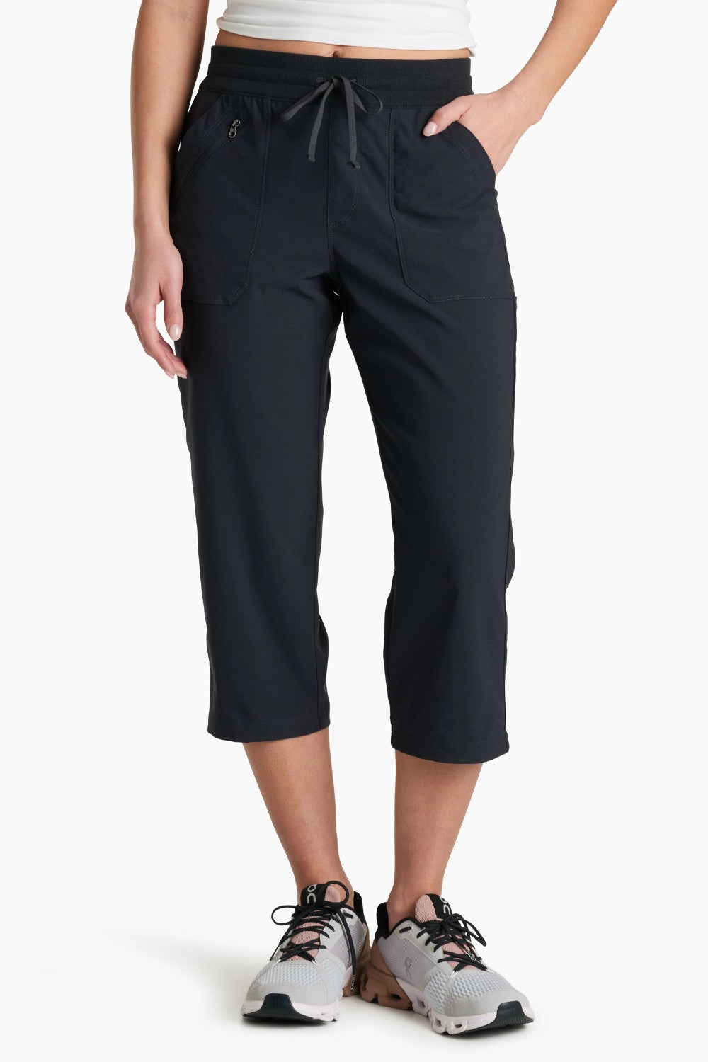 Person wearing black capri pants on a white background