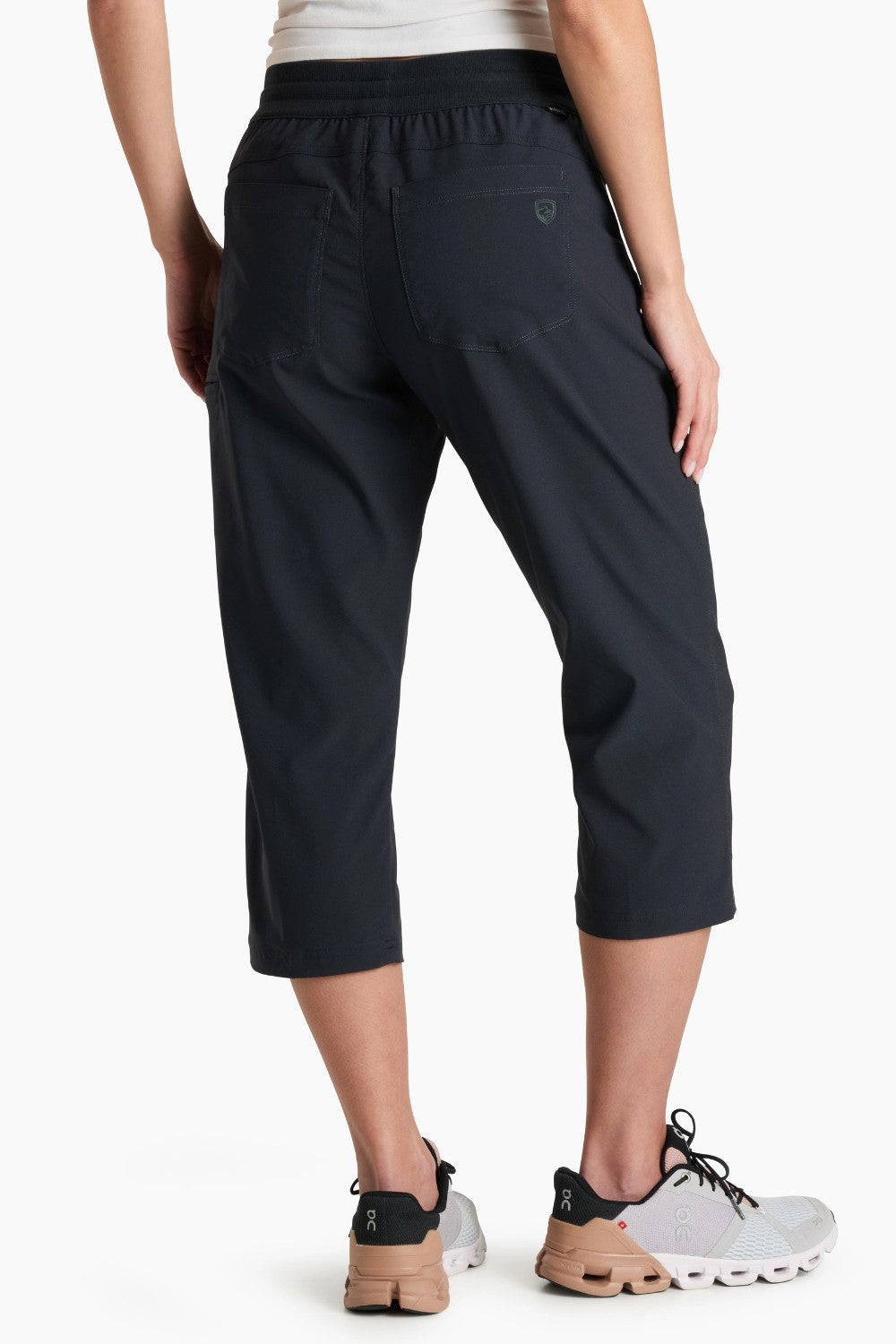 Person wearing black capri pants on a white background
