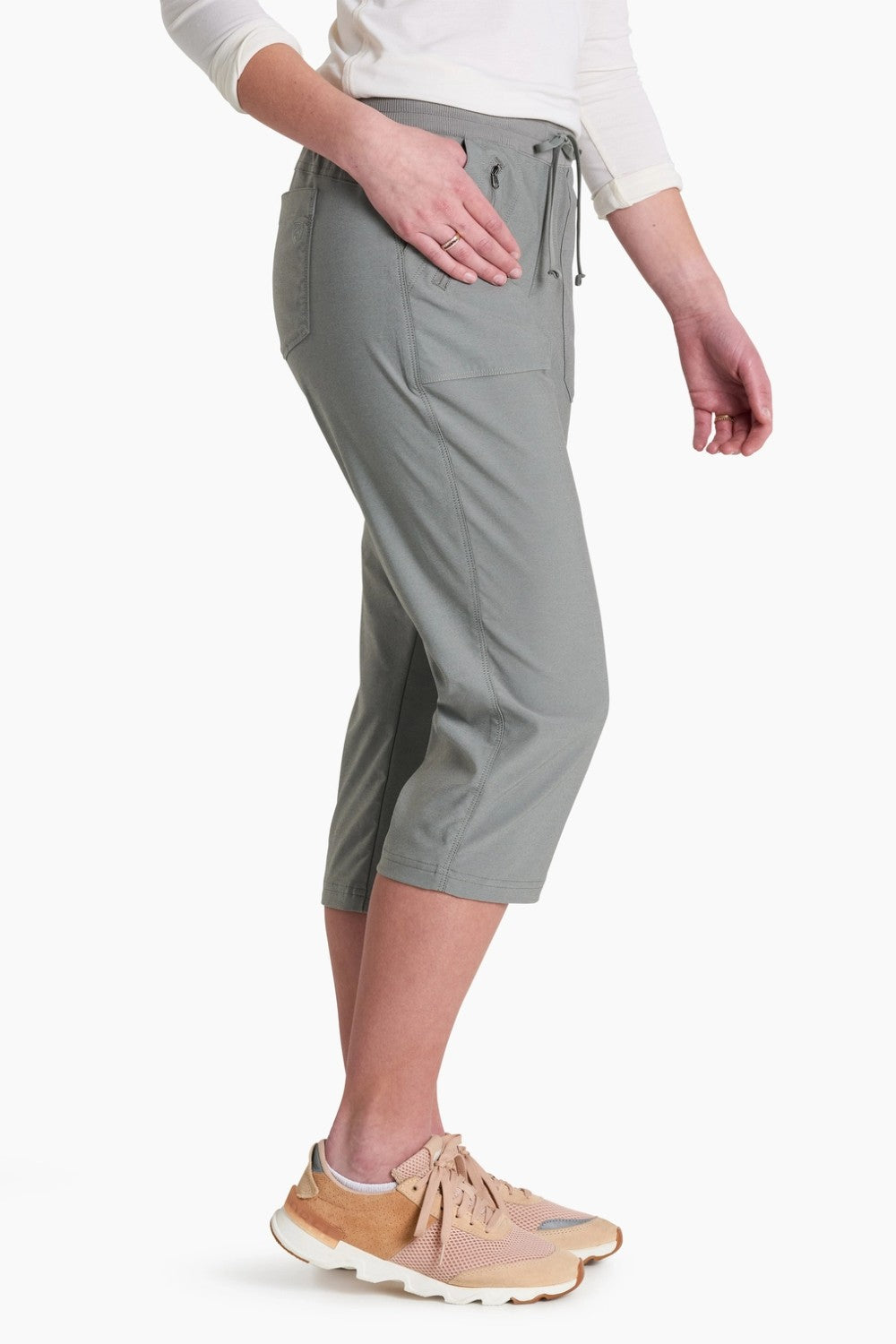 Person wearing gray capri pants on a white background