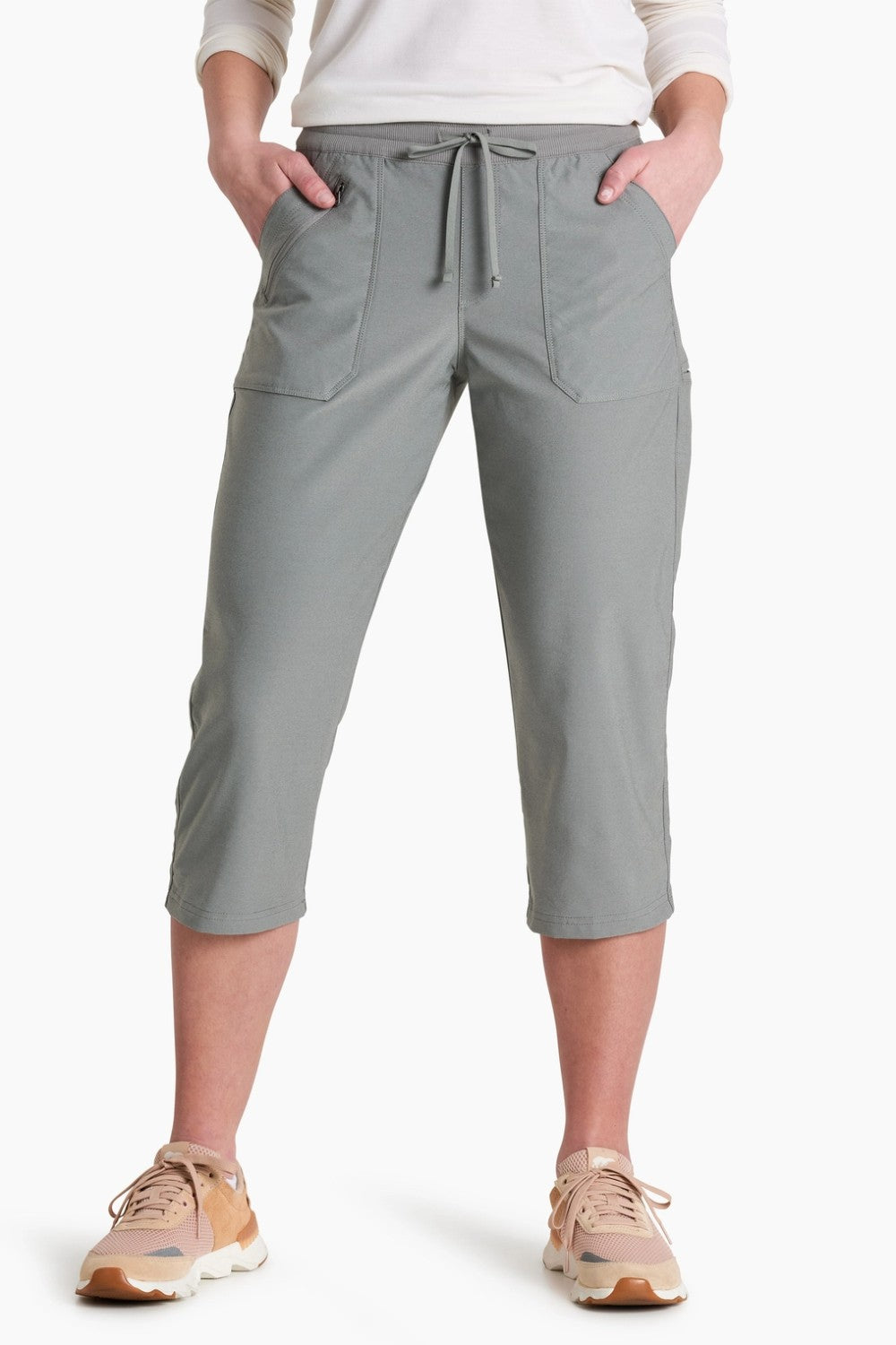 Person wearing gray capri pants on a white background