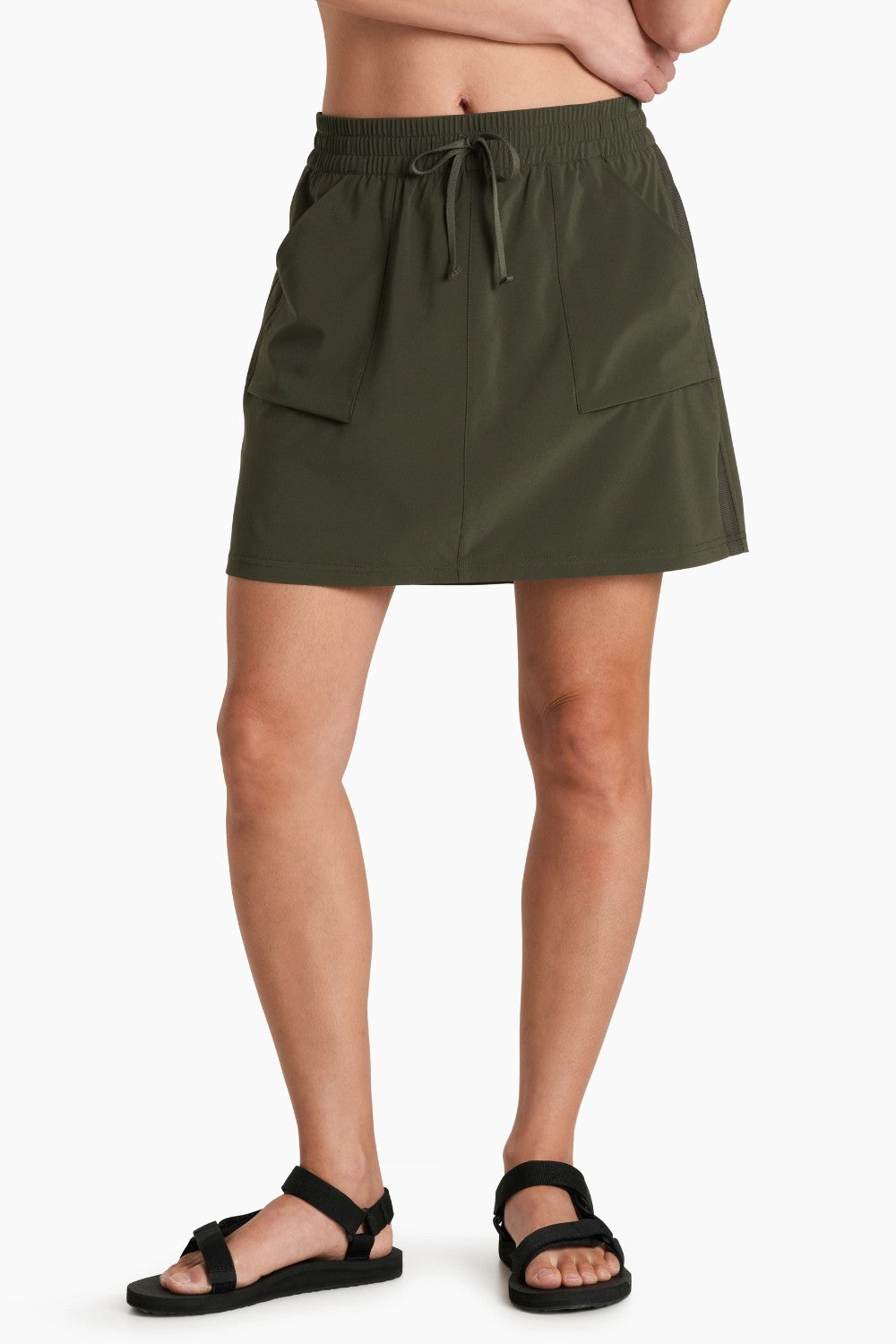 Person wearing a green skort on a white background