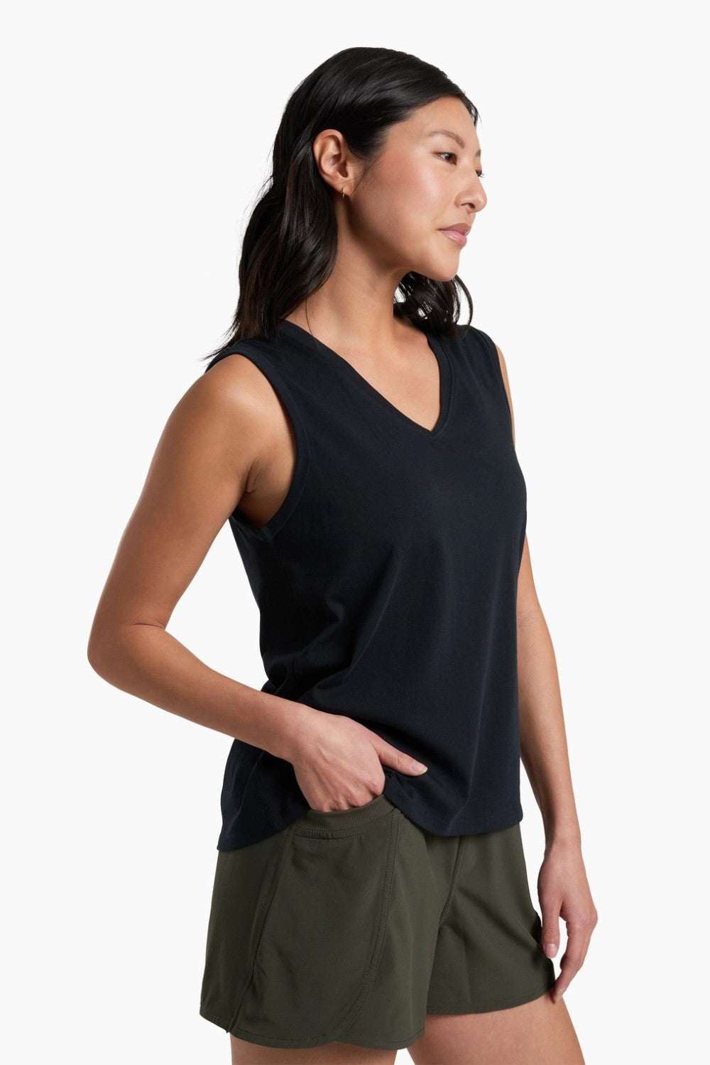 Woman wearing a black sleeveless top and green shorts on a white background