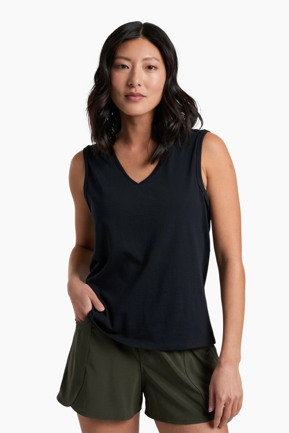 Woman wearing a black sleeveless top and green shorts on a white background