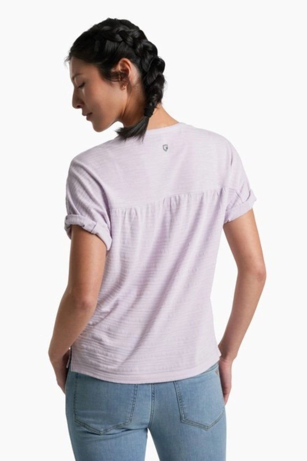 Person wearing a soft purple top with blue jeans on a white background