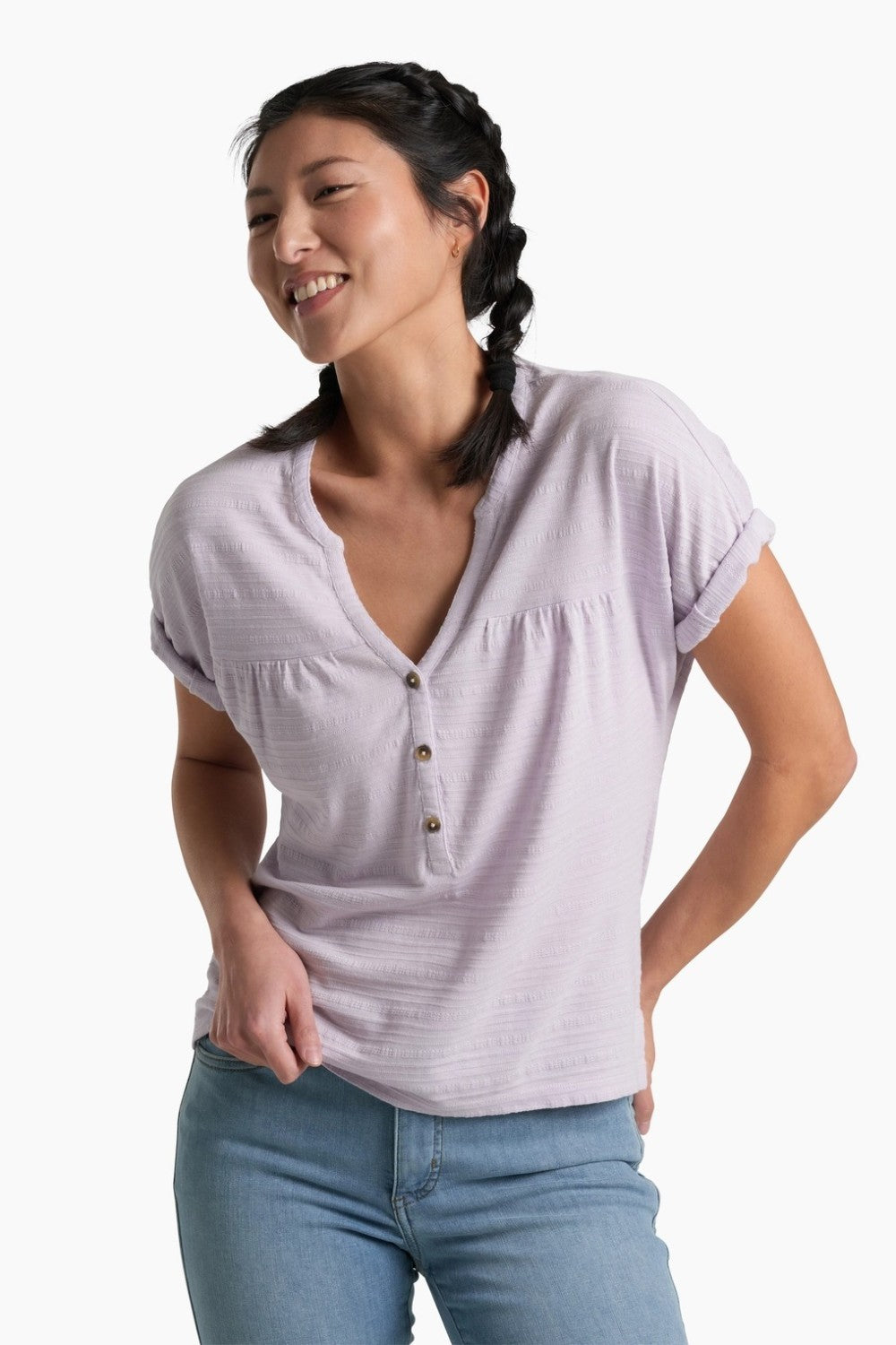 Person wearing a soft purple top with blue jeans on a white background