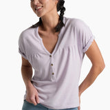 Person wearing a soft purple top with blue jeans on a white background