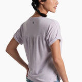 Person wearing a soft purple top with blue jeans on a white background