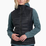 Woman wearing a black puffer vest over a teal sweater on a white background