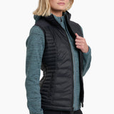 Woman wearing a black puffer vest over a teal shirt on a white background
