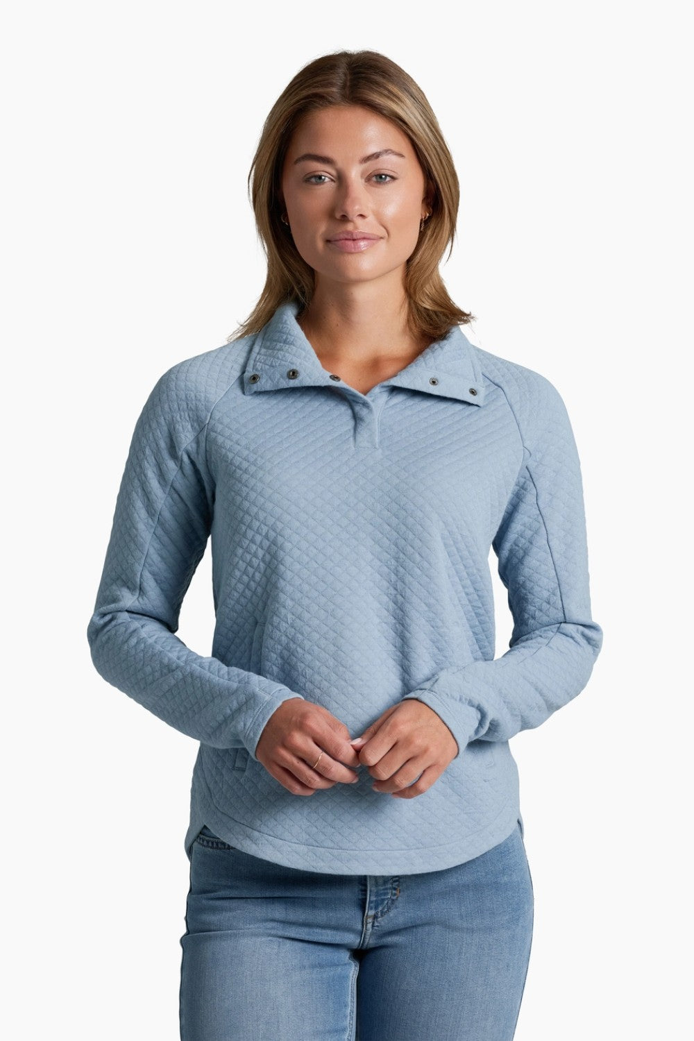 Woman wearing a light blue quilted sweater on a white background