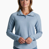 Woman wearing a light blue quilted sweater on a white background
