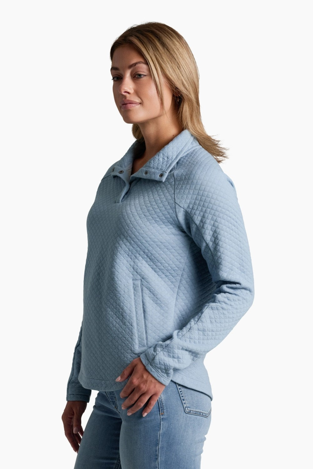 Woman wearing a light blue quilted sweater on a white background
