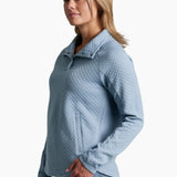 Woman wearing a light blue quilted sweater on a white background