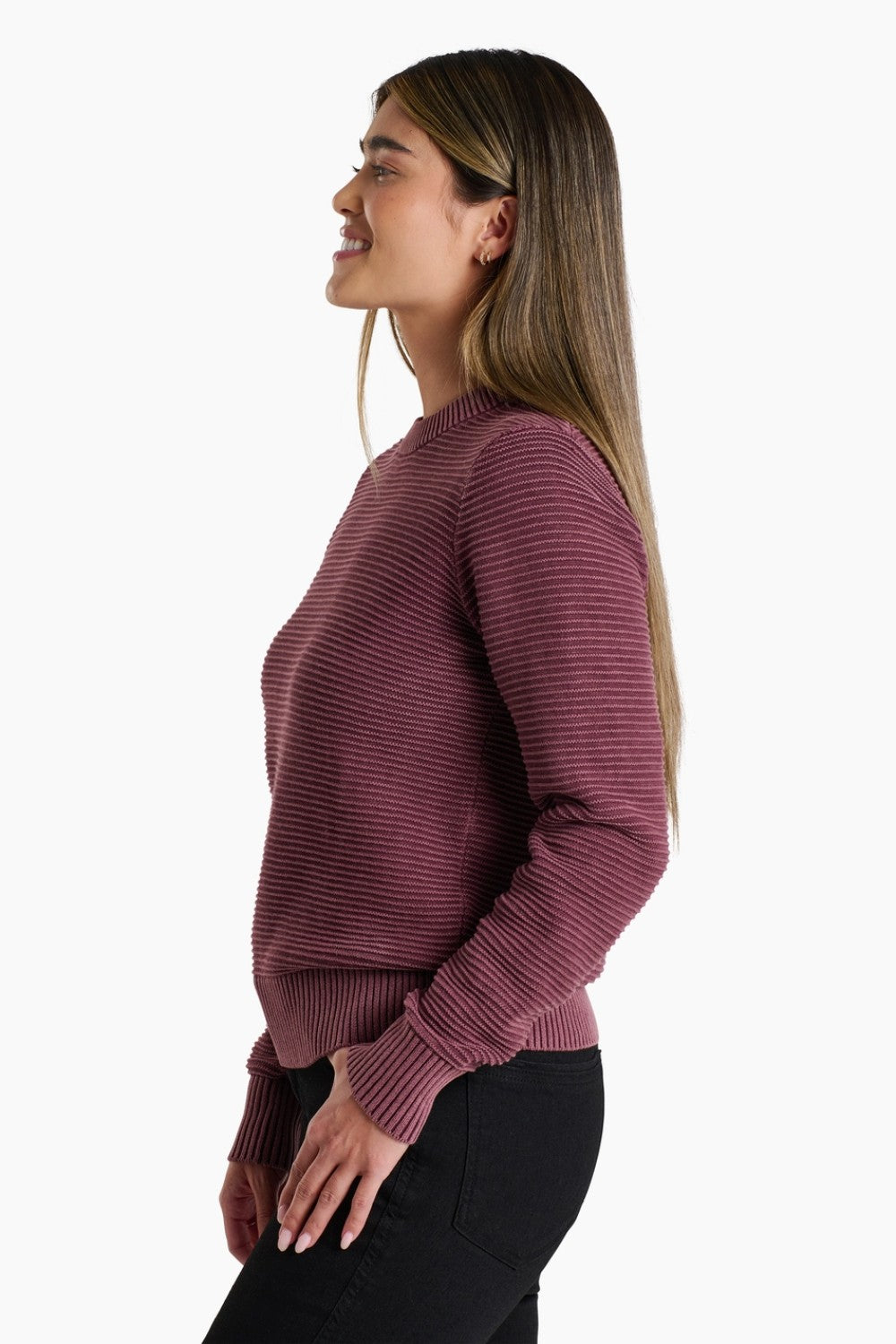 Woman wearing a maroon ribbed sweater on a white background