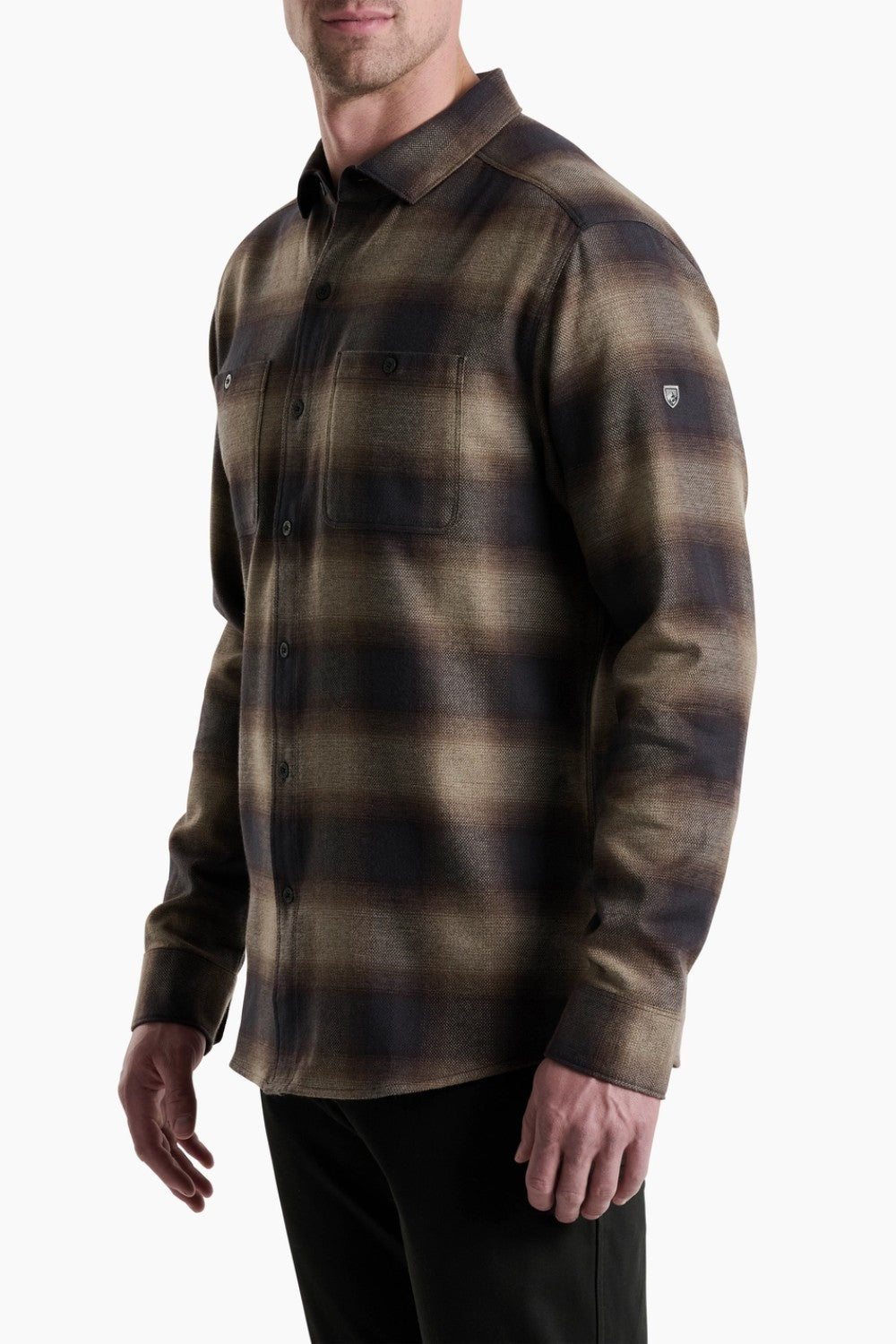 Man wearing a plaid shirt with a visible brand logo on a white background