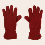 Pair of red gloves on a beige background