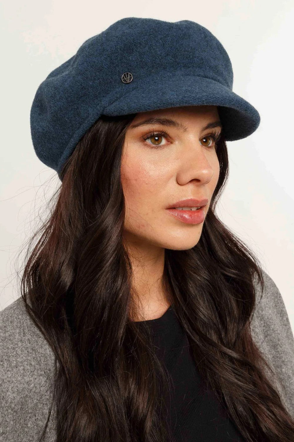 Woman wearing a blue cap against a white background