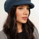 Woman wearing a blue cap against a white background
